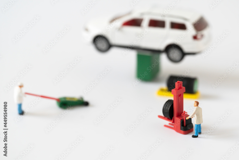 Miniature people Mechanic Labor Team changing car tire working in garage automobile service using for Car Automotive maintenance repair fixed or replacement Service or Vehicle Insurance guarantee Miniature people Mechanic Labor Team changing car tire working in garage automobile service using for Car Automotive maintenance repair fixed or replacement Service or Vehicle Insurance guarantee