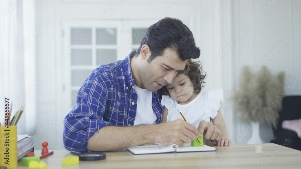Father with his toddler daughter girl child learning with pleasant dad at home. Children education, home schooling concept Father with his toddler daughter girl child learning with pleasant dad at home. Children education, home schooling concept