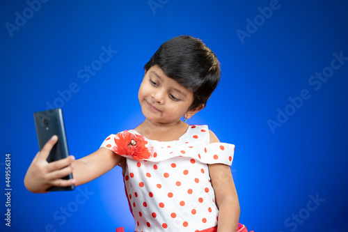 Photography Little Girl kid or toddler taking selfie and checking photos from mobile phone o