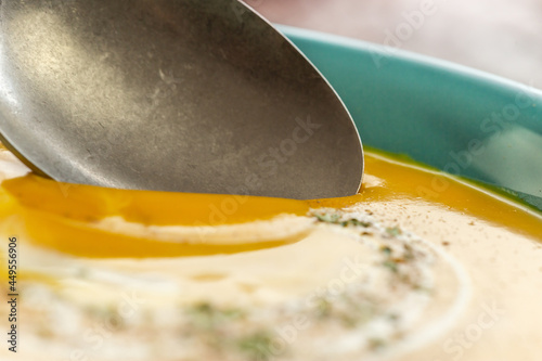 Close-up of a spoon dipping in a pumpkin soup photo
