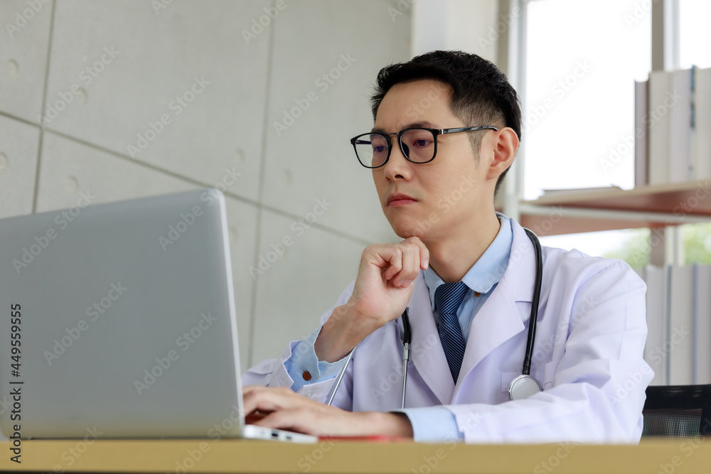 portrait asian doctor sitting at work on laptop computer portrait asian doctor sitting at work on laptop computer