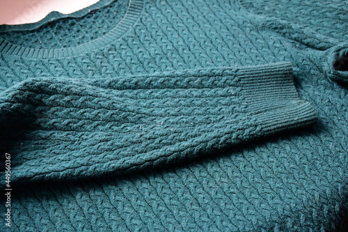 A thin knitted pullover or sweatshirt with spools on the surface after several washes. Defects in knitwear. Worn clothes.