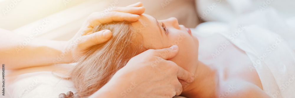 Fototapeta premium real doctor osteopath hands does physiological therapy for eight year old kid girl. pediatric osteopathy treatment session. alternative medicine. taking care of the child's health. banner. flare
