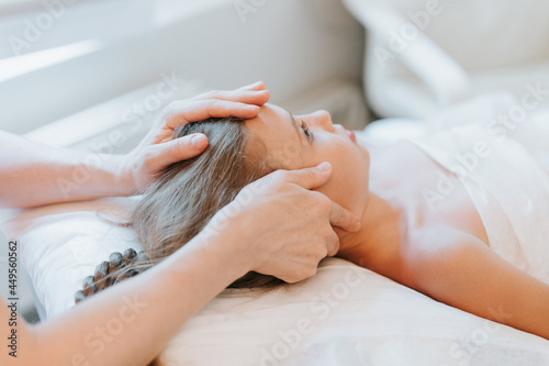 real doctor osteopath hands does physiological and emotional therapy for eight year old kid girl. pediatric osteopathy treatment session. alternative medicine. taking care of the child's health