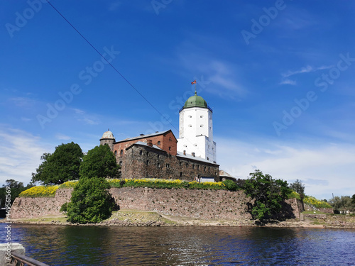 View from the embankment of the Vyborg Castle and the St. Olaf Tower  built in the 13th century  in the city of Vyborg against the blue sky.