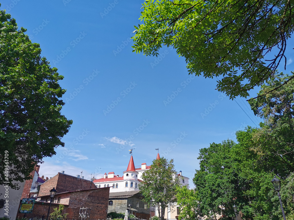 View from the park of a modern residential building with towers and outbuildings on a sunny summer day in Vyborg.