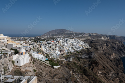 White top of buildings in Santorini, Greece with blue sky in a sunny warm day in July 2021.