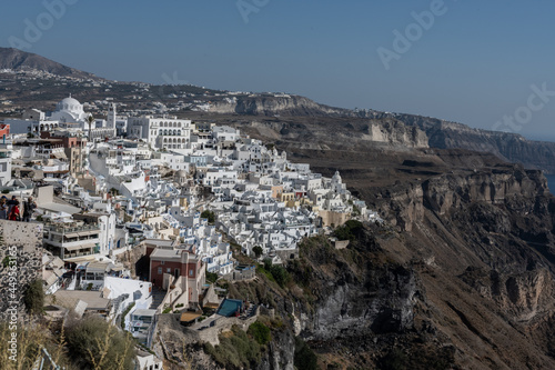 White top of buildings in Santorini, Greece with blue sky in a sunny warm day in July 2021.
