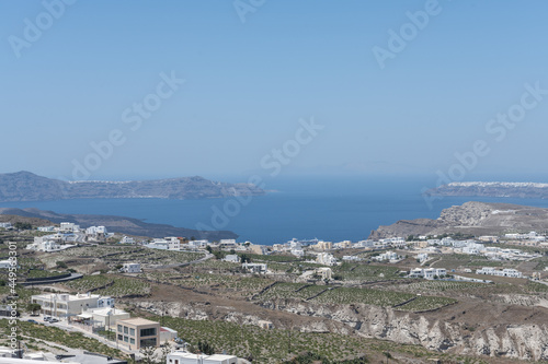 White top of buildings in Santorini, Greece with blue sky in a sunny warm day in July 2021.