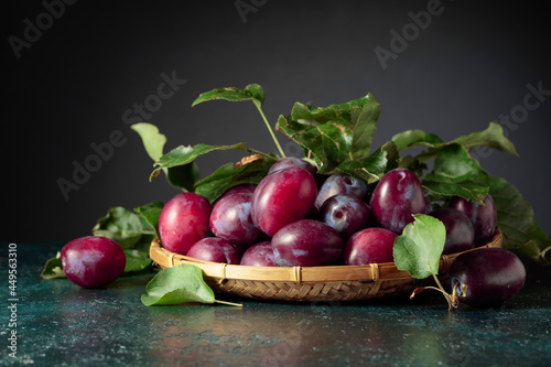 Purple plums with leaves.