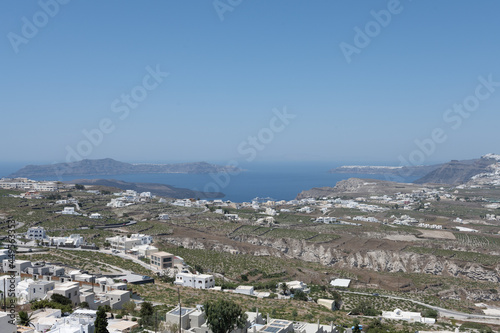 White and blue top of buildings in Pyrgos Santorini, Greece with blue sky in a sunny warm day in July 2021.