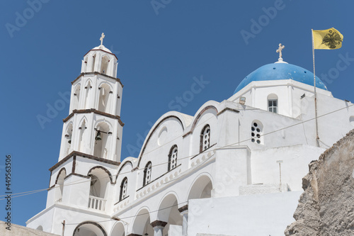 White and blue top of buildings in Pyrgos Santorini, Greece with blue sky in a sunny warm day in July 2021.