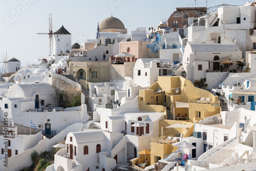 White and blue top of buildings in Pyrgos Santorini, Greece with blue sky in a sunny warm day in July 2021.