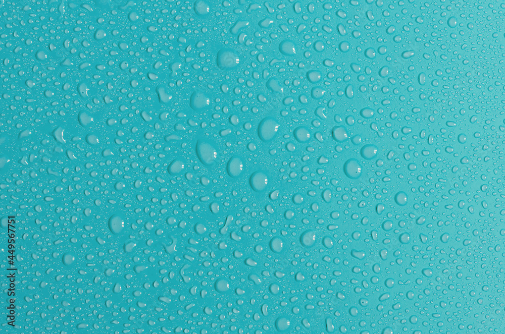 Blue-green background with large and small water drops. The texture of a water drop on a colored background is a top view.