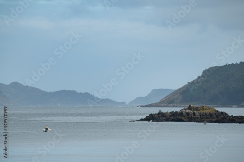 Rocky area and breakwater in the Pontevedra estuary on the Atlantic coast of Galicia with some in fishermen boats