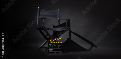 Black director chair and Clapperboard or movie slate use in video production or movie and cinema industry. It's black and yellow color.. photo