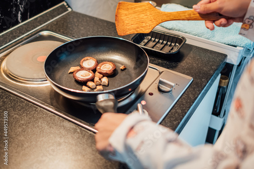 grill brown mushroom on black pan for prepare the breakfast.