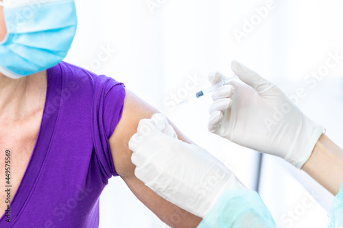 Women wearing masks getting vaccinated. Concept of coronavirus, vaccination elderly woman mask who approved covid-19 vaccination at hospital. Female doctor immunizes elderly patients against the virus