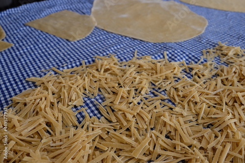 Preparing process of homemade Turkish noodle, selective focus. Noodles are the pasta that Turkish women make. It is called "Eriste", "Makarna" or "Kesme" in Turkish. Yeast dough dry with sun.