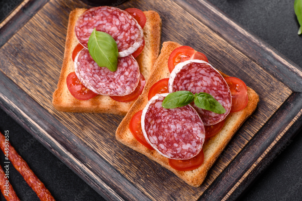 Spanish dried sausage salami on a dark concrete background Spanish dried sausage salami on a dark concrete background