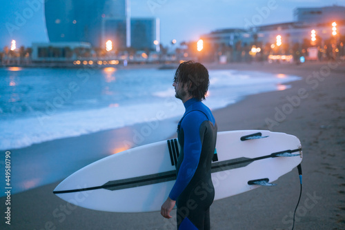Canvas Print Side view portrait of surfer standing holding surf board, ready for surfing at B