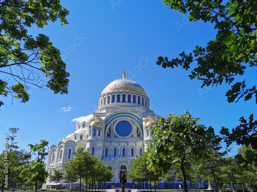 View of the square and the St. Nicholas Cathedral among the trees, built in 1903, on a summer day in Kronstadt.
