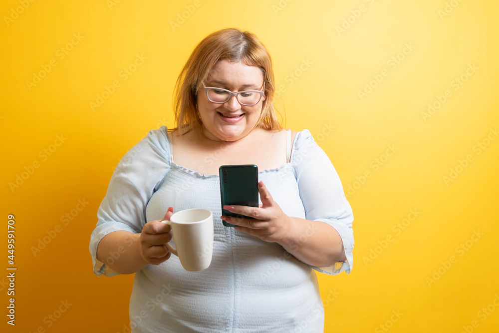 beautiful and happy young caucasian fat woman smiling with cup of coffee and mobile phone. overweight person