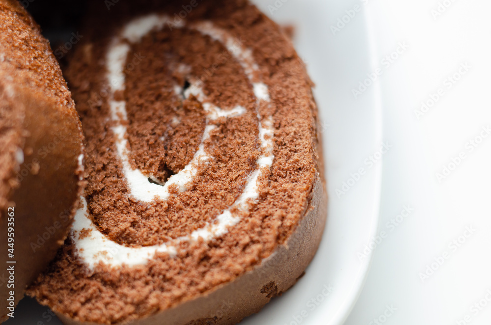 Chocolate sponge roll with a vanilla flavour filling, chocolate swiss roll Chocolate sponge roll with a vanilla flavour filling, chocolate swiss roll