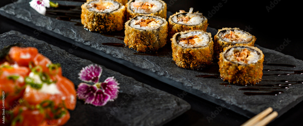 traditional thai food sushi temaki on a black background and hot roll