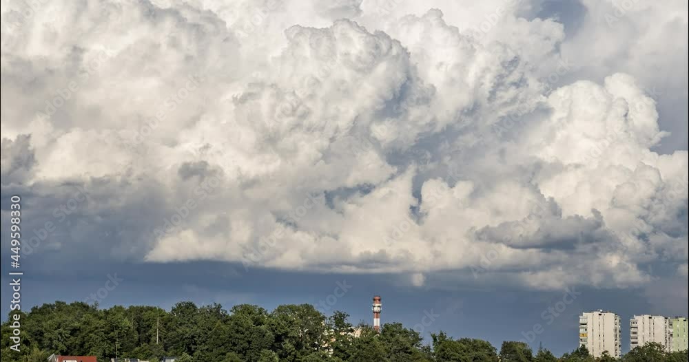 Time lapse of storm clouds moving over town Kranj, Slovenia. White puffy clouds in summer season. Chimney and skyscrapers in the foreground. Dramatic clouds forming into the storm. Static shot Time lapse of storm clouds moving over town Kranj, Slovenia. White puffy clouds in summer season. Chimney and skyscrapers in the foreground. Dramatic clouds forming into the storm. Static shot