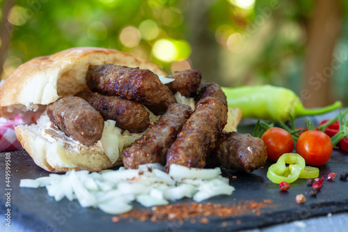 Grilled kebab, turkish style barbecued minced meat with onion. Traditional Balkan food - cevapi or cevapcici. photo