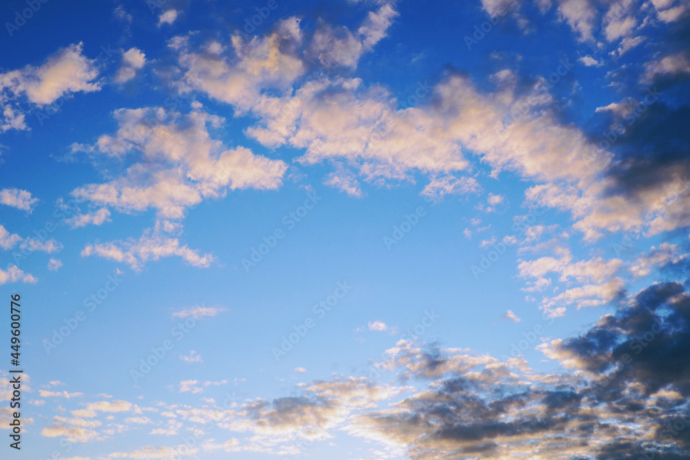 Blue sky, light and dark clouds at sunset. Cloudscape copy-space background or wallpaper. Central place for text