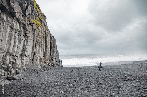 Panoramic view  of Reynisfjara beach cave in Iceland with big basalt pillars and rocky beach. Cold windi place at the beach with big waves. photo