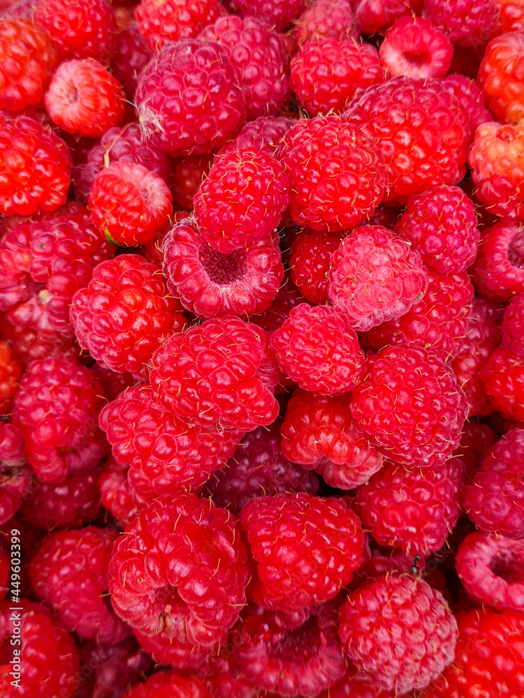 Raspberry background. Fresh, juicy, red berries of ripe raspberries lie one on one creating a beautiful natural and delicious background, use for wallpaper, close-up top view Raspberry background. Fresh, juicy, red berries of ripe raspberries lie one on one creating a beautiful natural and delicious background, use for wallpaper, close-up top view