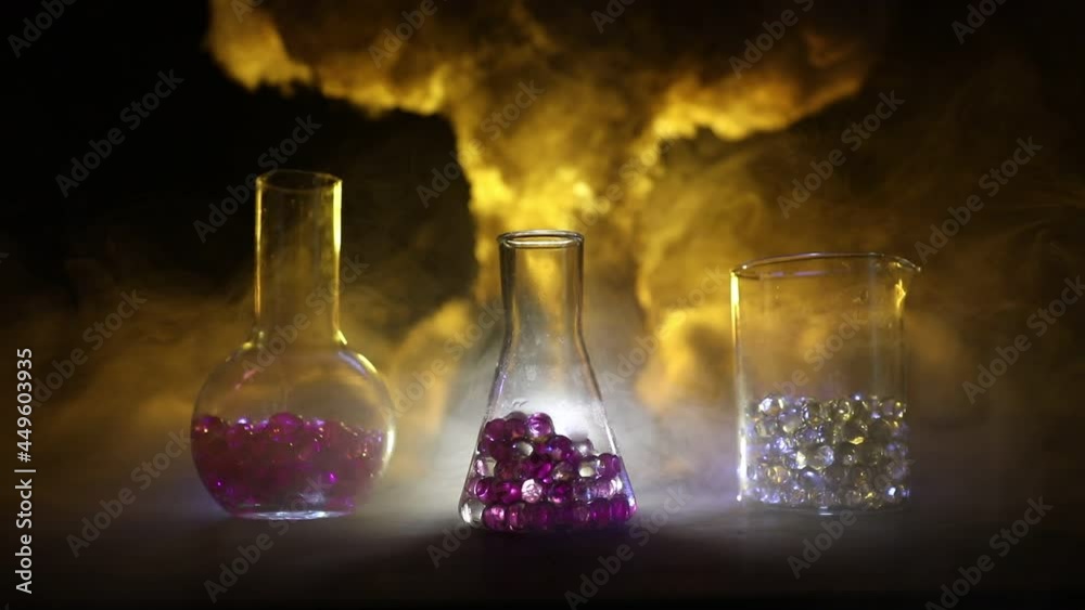 Pharmacy and chemistry theme. Test glass flask with solution in research laboratory. Science and medical background. Laboratory test tubes on abstract explosion cloud background. Selective focus