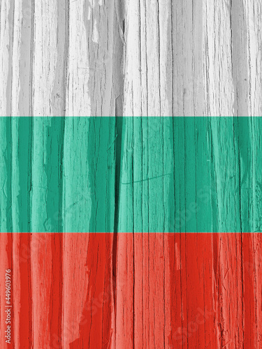 Fragment of the flag of Bulgaria on dry cracked wooden surface. It seems to flutter in the wind. Vertical bright illustration with Bulgarian national symbol. Hard sunlight with shadows on old wood