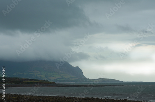 Stormy seascape, Trefor, north Wales. Dramatic skies with clouds around the coastal mountains of the beautiful Llyn peninsula. Copy space.