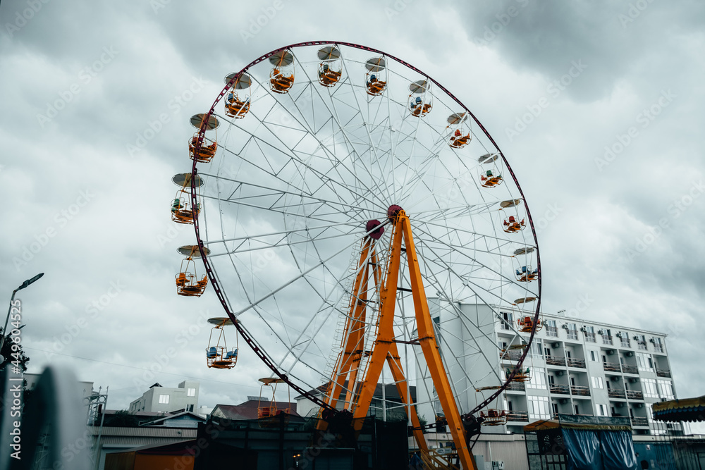 Ferris wheel against a stormy sky background.