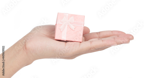 Hand holding Pink gift box with ribbon and bow isolated on white background