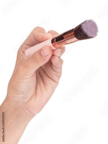 Hand holding Makeup brush isolated on white background.