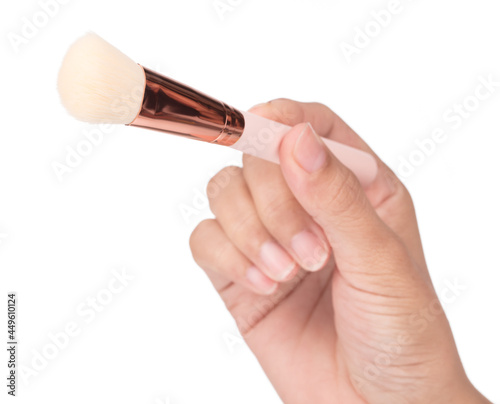 Hand holding Makeup brush isolated on white background.