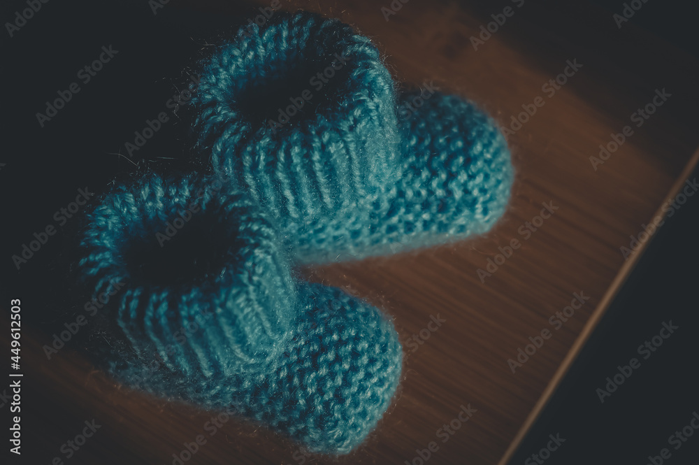 A pair of blue booties for a small child. Early morning, light from the window. A pair of blue booties for a small child. Early morning, light from the window.