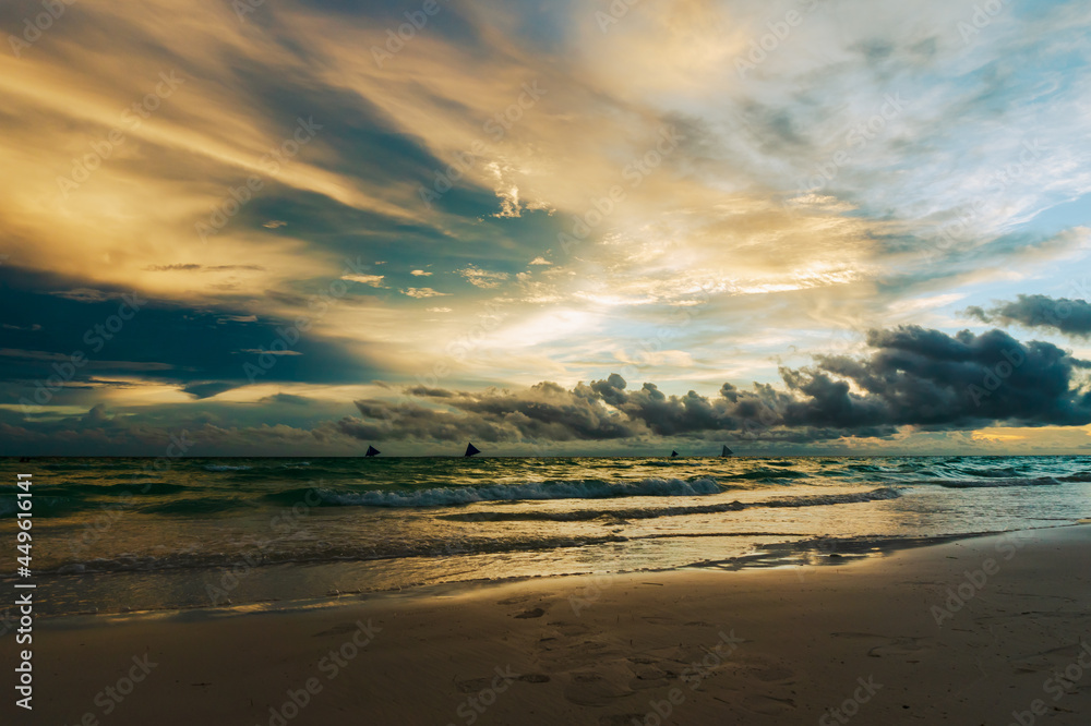 Dramatic sunset with with a view of salibotats over White beach in Boracay Island, Philippines.  Travel and nature.