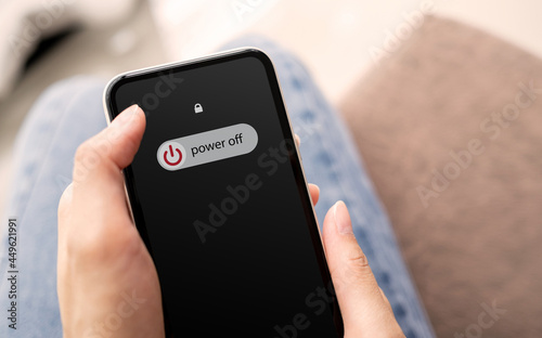 Murais de parede Woman hand using is sliding to turn off the mobile phone to reduce power consumption