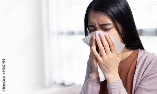 Young Asian women cover their mouth and nose with tissues during the flu, coughing and sneezing to prevent spreading the virus. Concept of health care and medicine