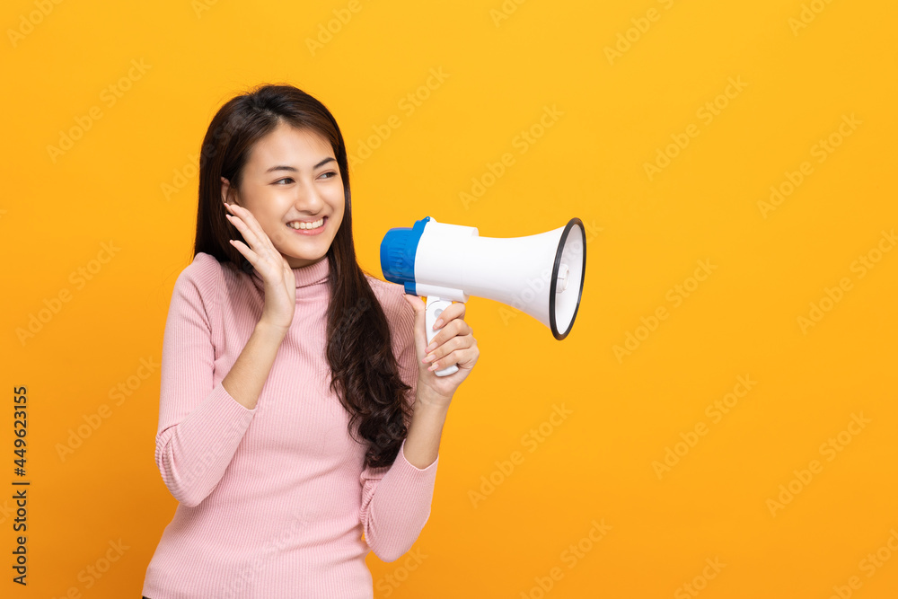 Shout out loud with megaphone. Young beautiful asian woman woman announces with a voice about promotions and advertisements for products at a discounted price. Shopping and fashion concept. Shout out loud with megaphone. Young beautiful asian woman woman announces with a voice about promotions and advertisements for products at a discounted price. Shopping and fashion concept.