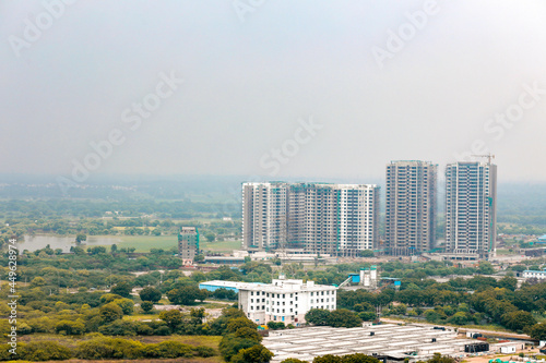 Arial view Cityscape in Gurgaon, Noida, Jaipur, Delhi NCR, Lucknow, Mumbai, Bangalore, Hyderabad showing small houses sky scrapers other commercial real estate infrastructure