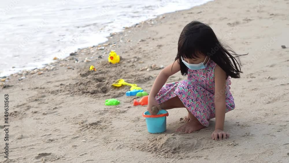 Chinese kid play sand at beach during pandemic coronavirus outbreak Chinese kid play sand at beach during pandemic coronavirus outbreak