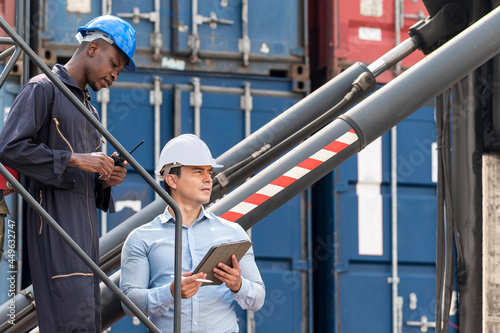 African American Environment engineer and young businessman working and discussing in shipping container in commercial transport port