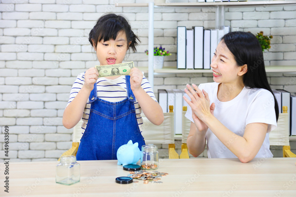 Asian mother is teaching her daughter the saving lesson for investment in education and future planning Asian mother is teaching her daughter the saving lesson for investment in education and future planning